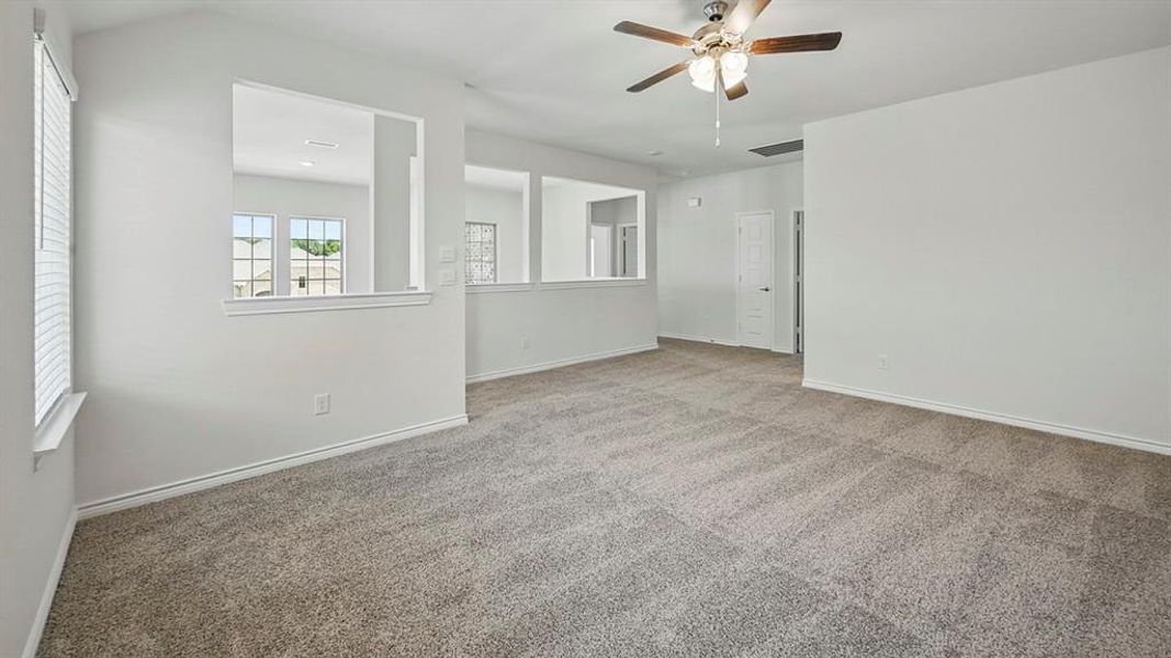 Carpeted spare room with a ceiling fan and baseboards Carpeted spare room with a ceiling fan and baseboards