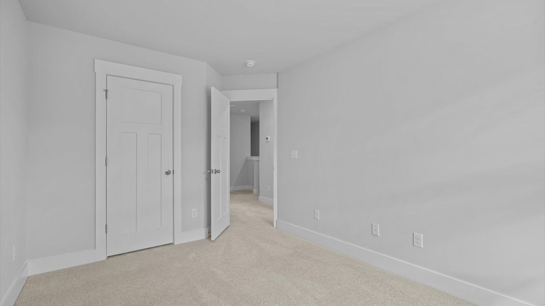 Superior comfort in a secondary bedroom with plush carpet and an oversized walk-in closet Superior comfort in a secondary bedroom with plush carpet and an oversized walk-in closet
