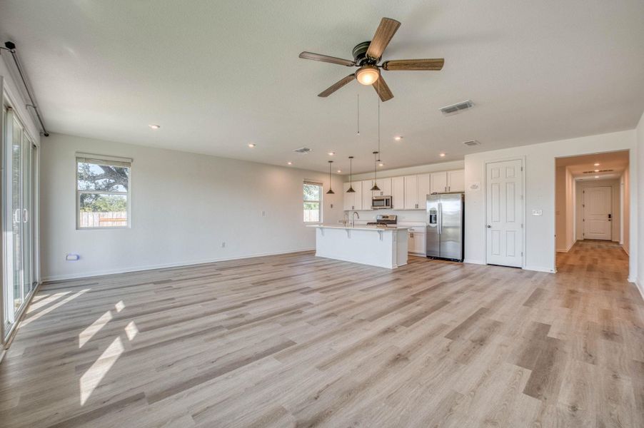 Plank flooring runs throughout this open-concept layout leading into the kitchen.