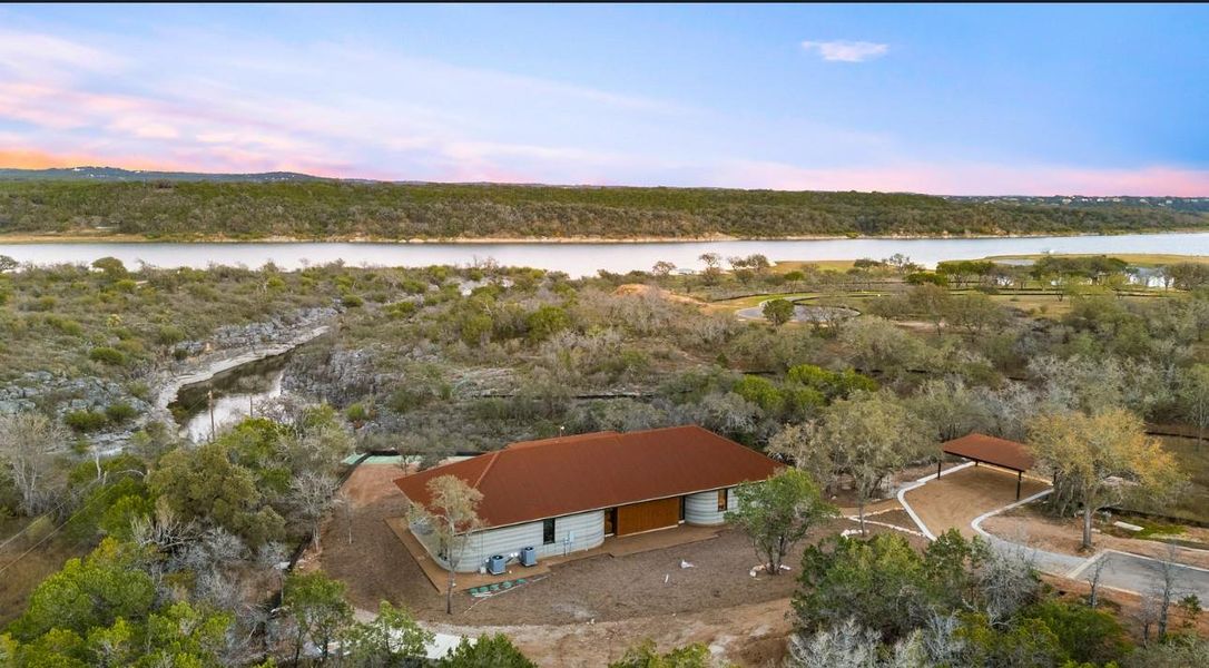 Aerial view of property and surrounding area with a nearby body of water