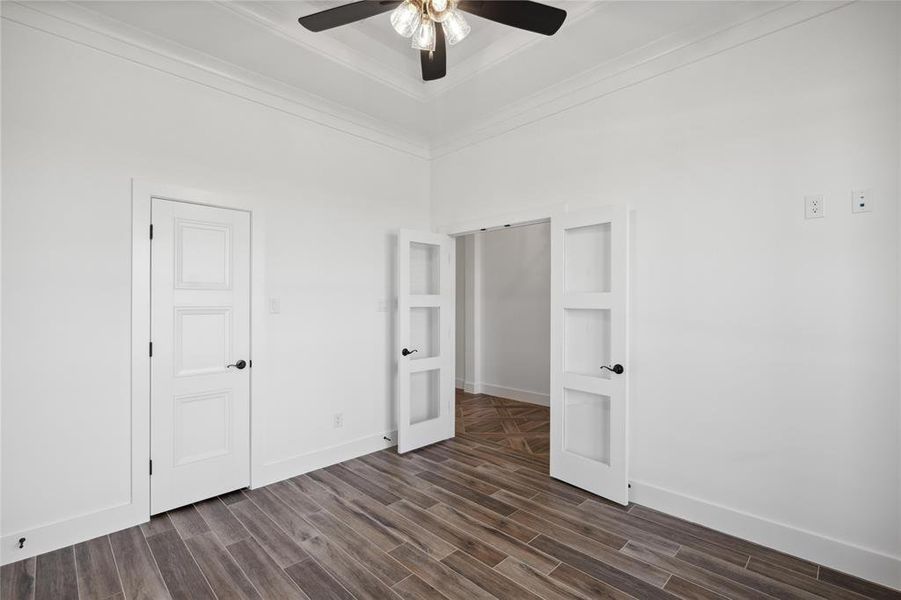 Unfurnished bedroom with dark hardwood / wood-style flooring and ceiling fan