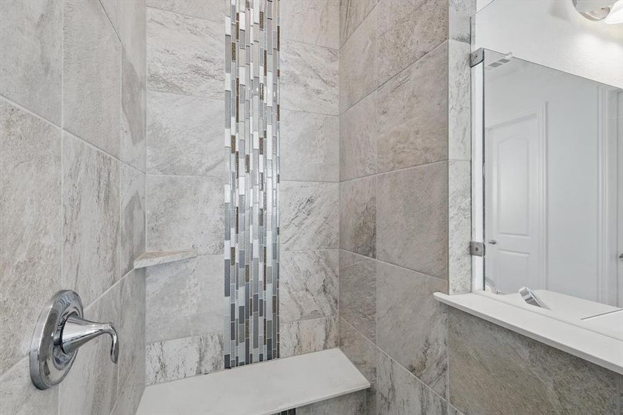 The Primary Bath shower is quite large with a shower seat & designer accents.