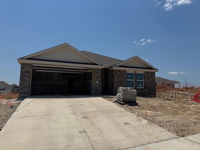 Ranch-style home featuring a garage, concrete driveway, and brick siding