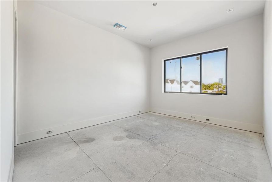 This secondary bedroom features large windows and 10 foot ceilings making it feel open and spacious.