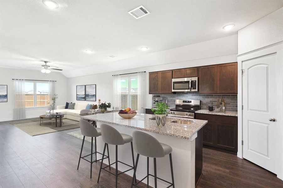 Kitchen featuring a center island with sink, appliances with stainless steel finishes, dark hardwood / wood-style floors, and plenty of natural light