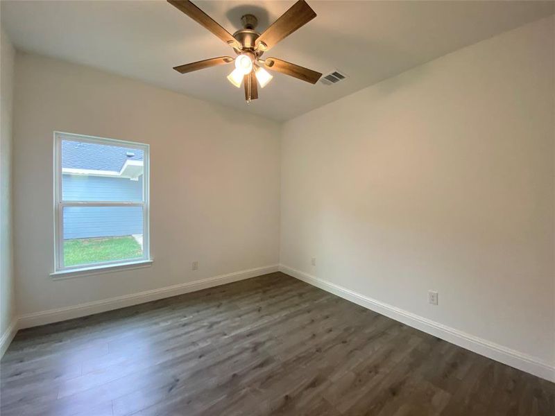 Spare room featuring dark wood finished floors and a ceiling fan Spare room featuring dark wood finished floors and a ceiling fan