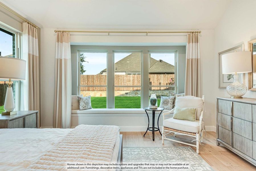 Bedroom with bay window seat, hardwood floors, and backyard view through large windows