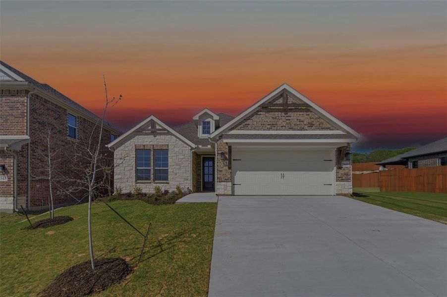View of front of property featuring stone siding, a garage, and driveway