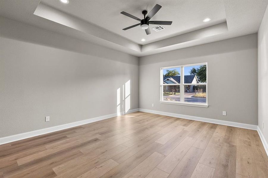 Spare room featuring a tray ceiling, recessed lighting, light wood-style flooring, and a ceiling fan Spare room featuring a tray ceiling, recessed lighting, light wood-style flooring, and a ceiling fan