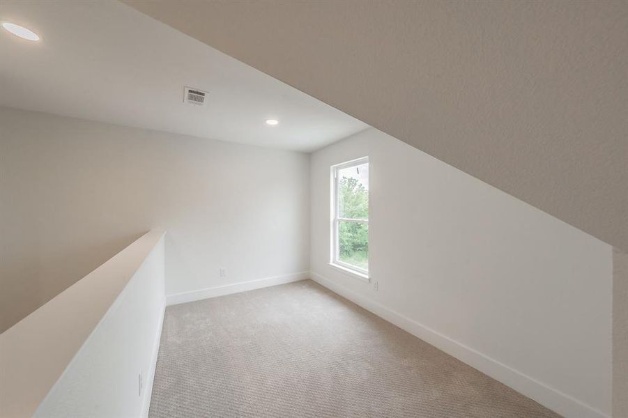 Additional living space featuring light carpet, baseboards, and recessed lighting