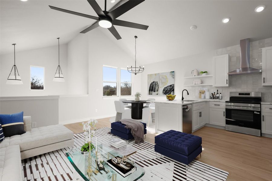 Living area featuring light wood-style floors, hanging lights, ceiling fan, and vaulted ceiling