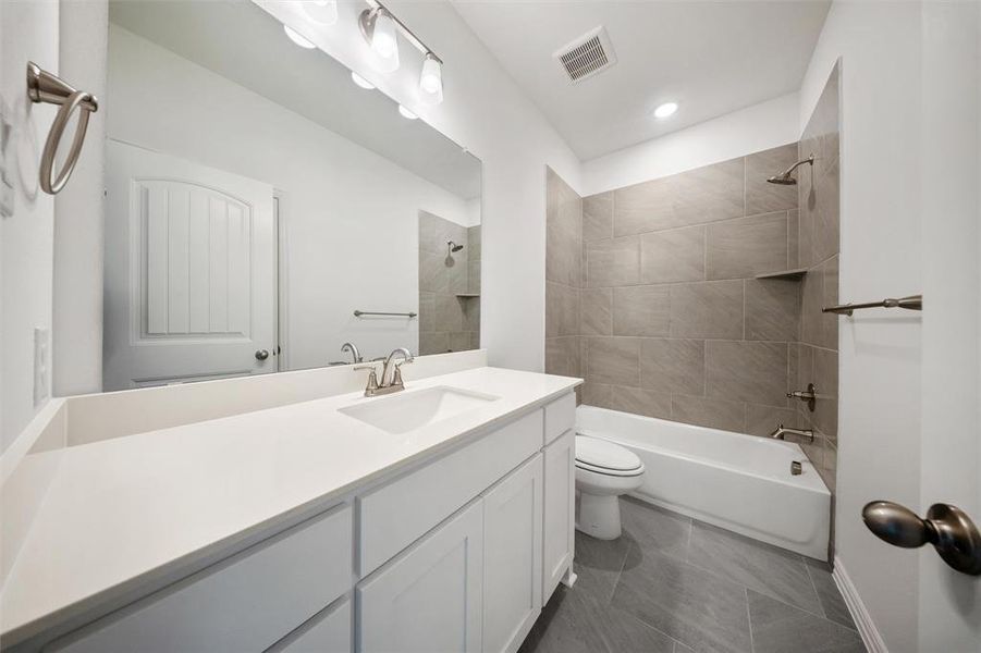 Bathroom with shower combination, vanity, dark tile patterned floors, and recessed lighting Bathroom with shower combination, vanity, dark tile patterned floors, and recessed lighting