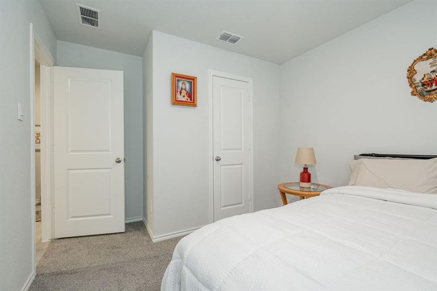 Carpeted bedroom featuring visible vents and baseboards