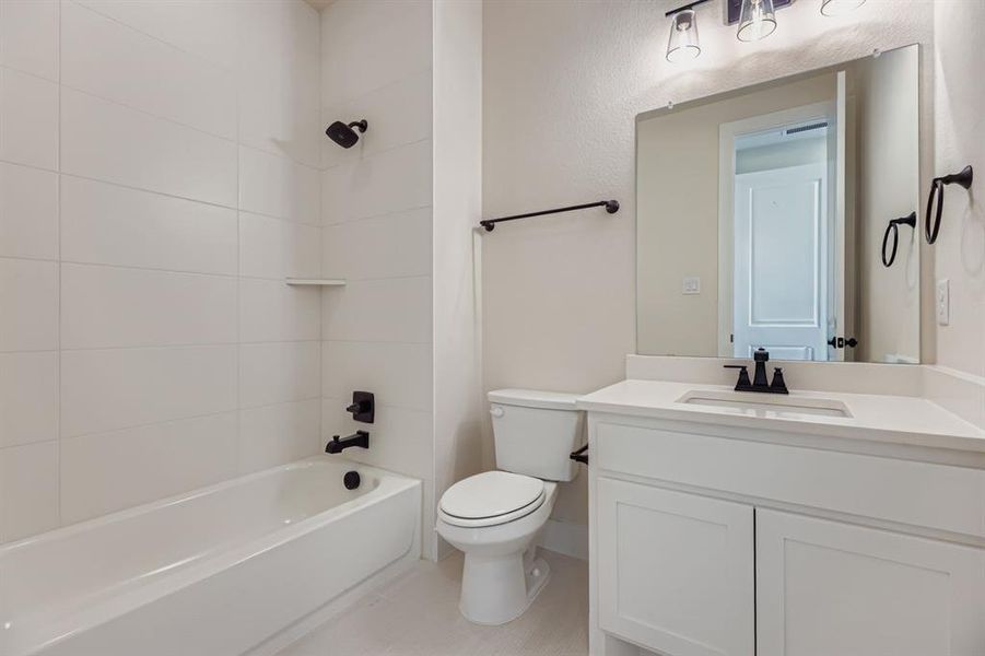 Bathroom featuring shower / bath combination, vanity, and light tile patterned flooring