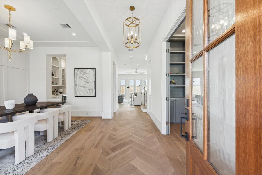 Bright, inviting entry with tall ceilings, hardwood floors, and a clear view into the home’s open living and dining spaces.