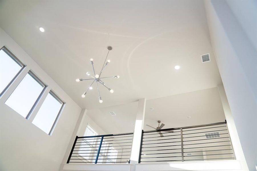 Vaulted ceiling with an exposed beam, modern sputnik chandelier, recessed lighting, and high windows Vaulted ceiling with an exposed beam, modern sputnik chandelier, recessed lighting, and high windows