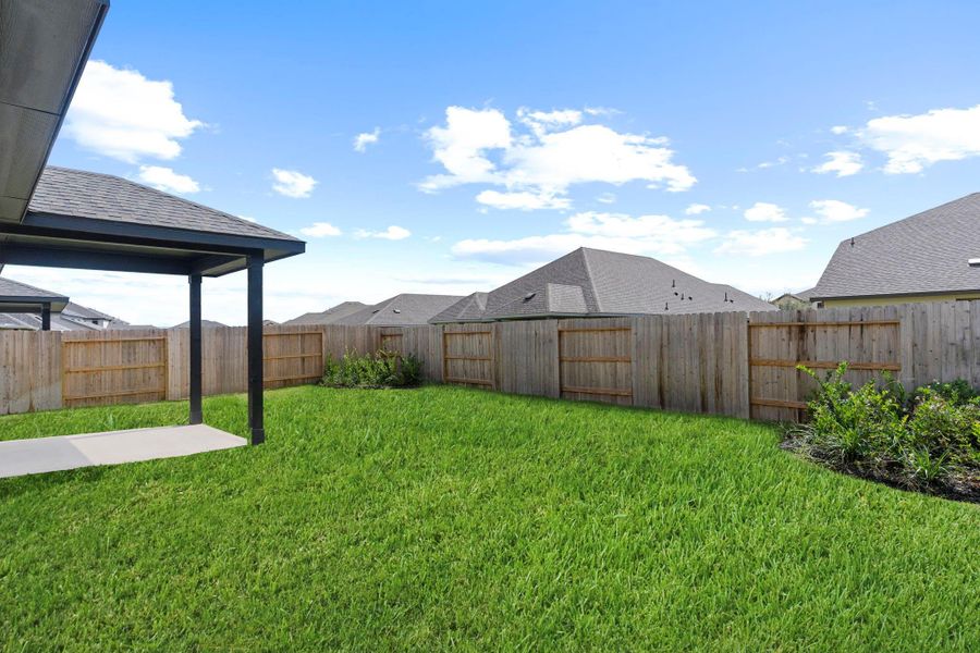 Another inviting view of the backyard featuring lush green grass, privacy fencing, and plenty of room to play, garden, or entertain guests. It’s a wonderful space for gatherings or quiet moments outdoors.