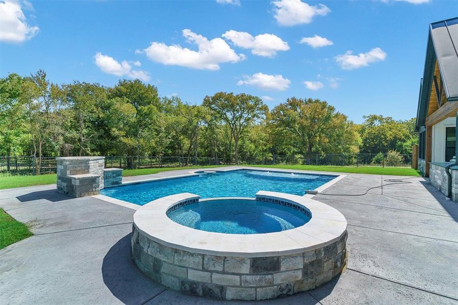 View of swimming pool featuring a patio and an in ground hot tub