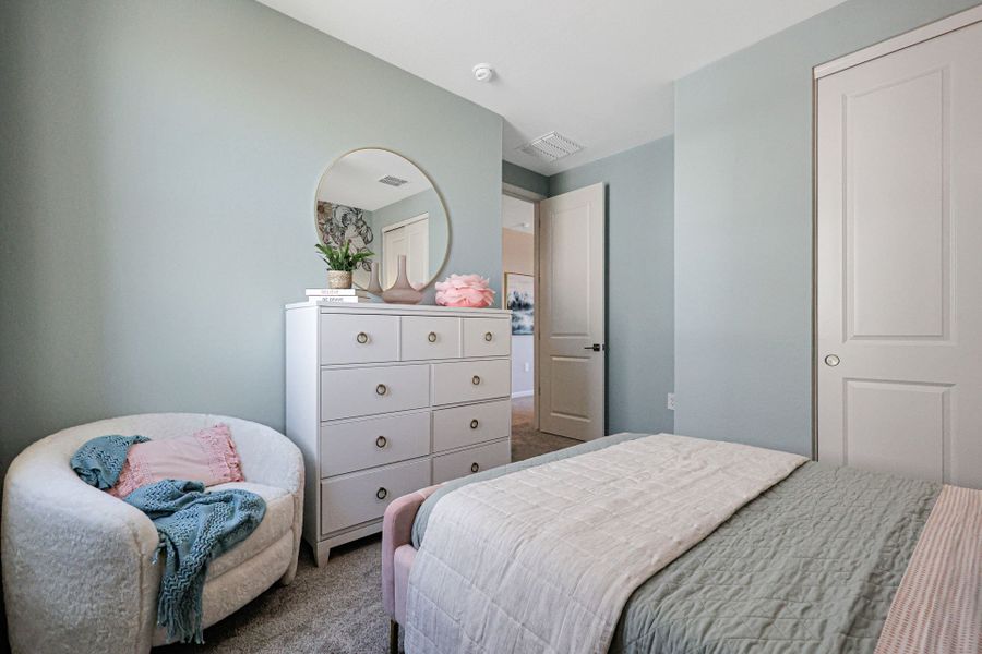 A bedroom with a mirror and dresser.