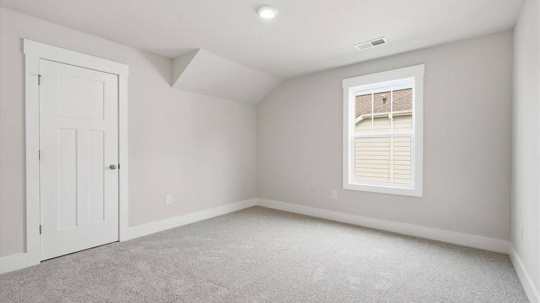 Notable bedroom offering soft carpet, a walk-in closet, and expansive windows