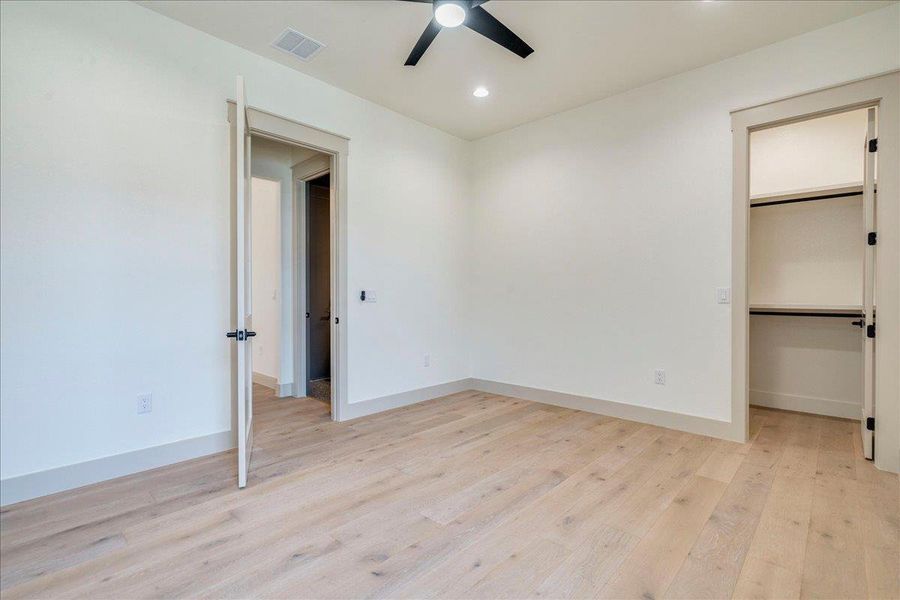 Hardwood floors and a ceiling fan complete this comfortably appointed room.