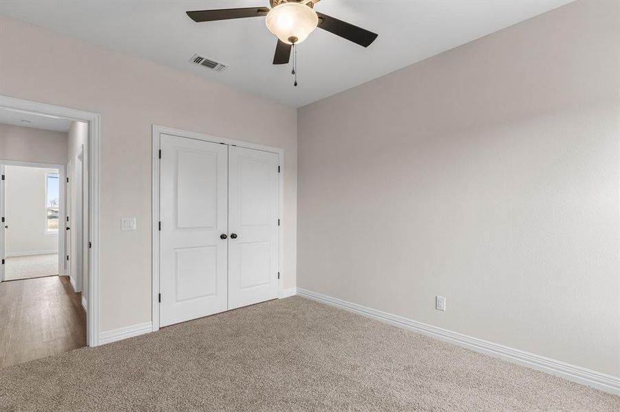 Unfurnished bedroom featuring carpet, ceiling fan, and a closet Unfurnished bedroom featuring carpet, ceiling fan, and a closet