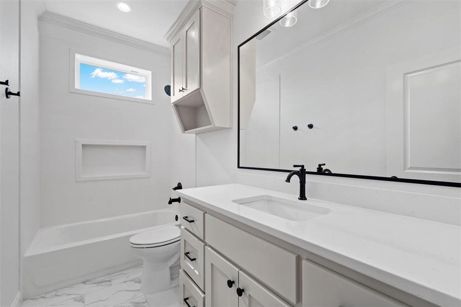 Bathroom with vanity, crown molding, shower / bath combination, and light marble finish floors Bathroom with vanity, crown molding, shower / bath combination, and light marble finish floors