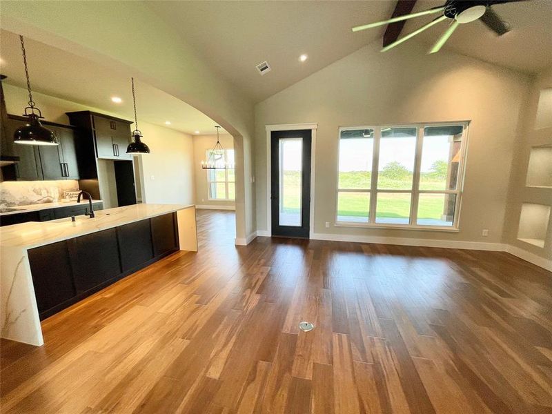 Kitchen featuring ceiling fan, hardwood / wood-style flooring, and high vaulted ceiling