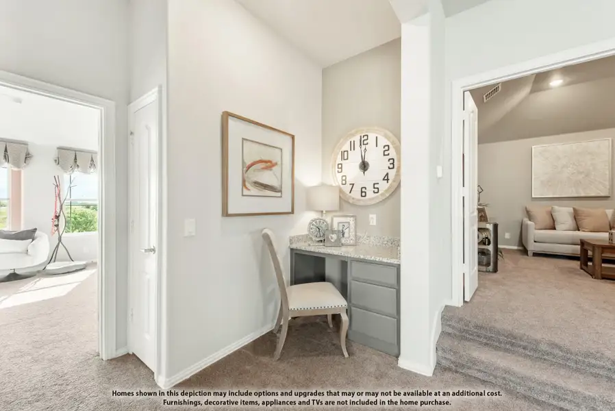 Built-in desk nook with gray cabinets and granite countertop in carpeted hallway with vaulted ceiling