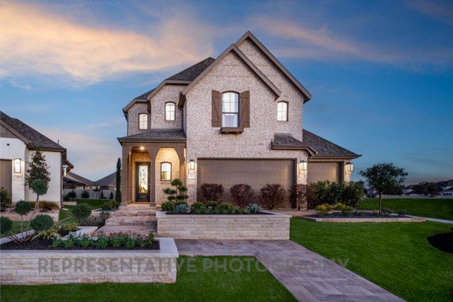 French country style house featuring brick siding, a lawn, and an attached garage French country style house featuring brick siding, a lawn, and an attached garage