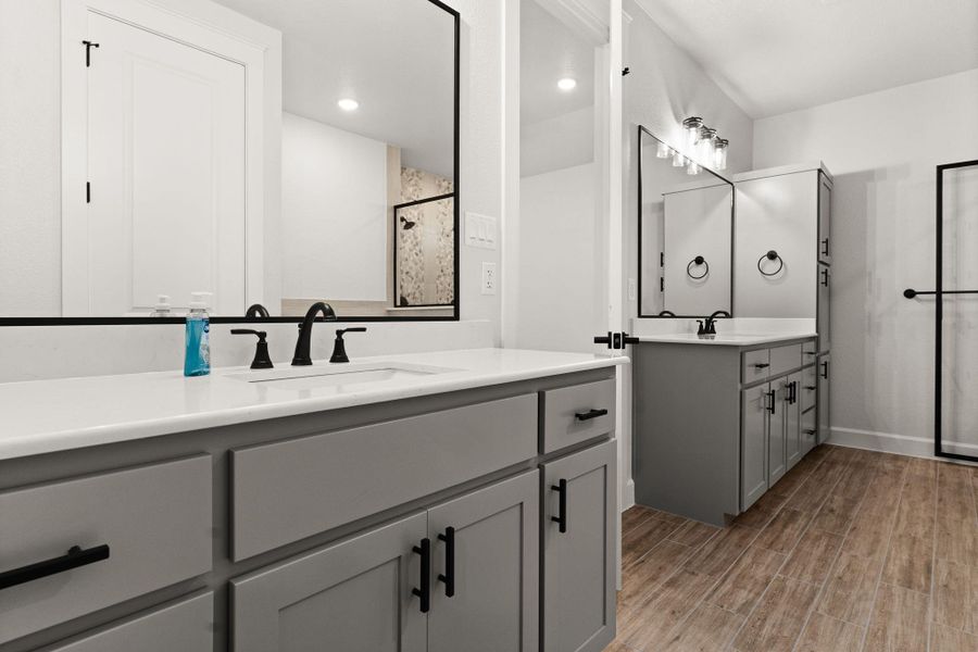 Bathroom featuring two vanities, wood tiled floors, tiled shower, and recessed lighting Bathroom featuring two vanities, wood tiled floors, tiled shower, and recessed lighting