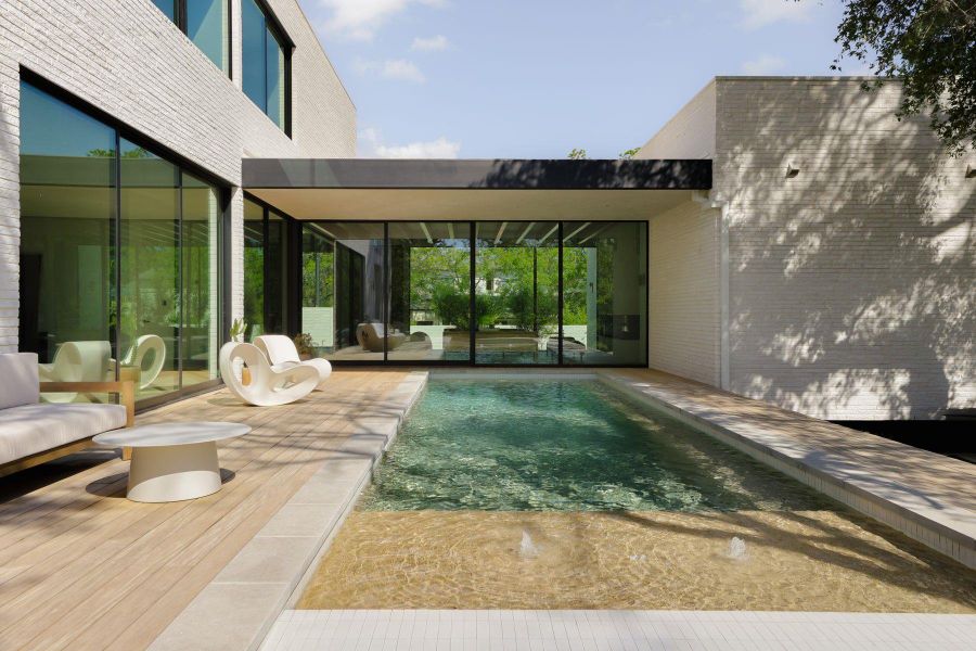 Rear view of property featuring an outdoor pool, a patio area, and brick siding