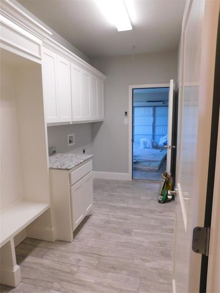 Laundry room featuring cabinets, light wood-type flooring, and hookup for a washing machine