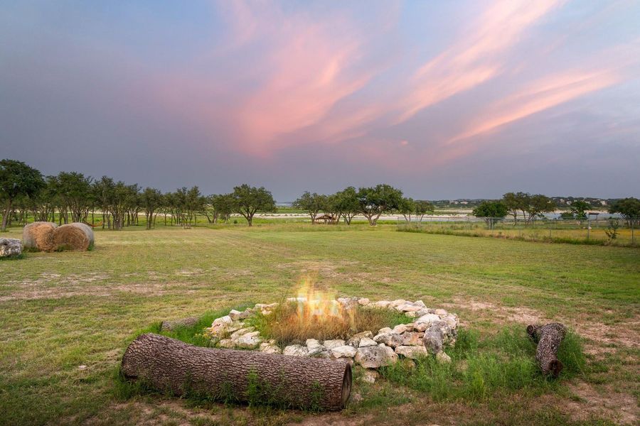 Unwind under Hill Country skies around the custom stone firepit, perfectly positioned in a spacious backyard made for gathering. This Canyon Lake retreat features a large deck, mature oaks, and room to relax or entertain—just steps from the water’s edge