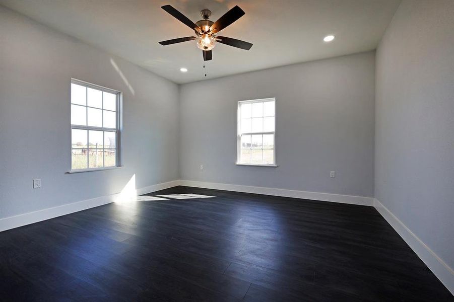 Empty room featuring dark wood finished floors, recessed lighting, and a ceiling fan Empty room featuring dark wood finished floors, recessed lighting, and a ceiling fan