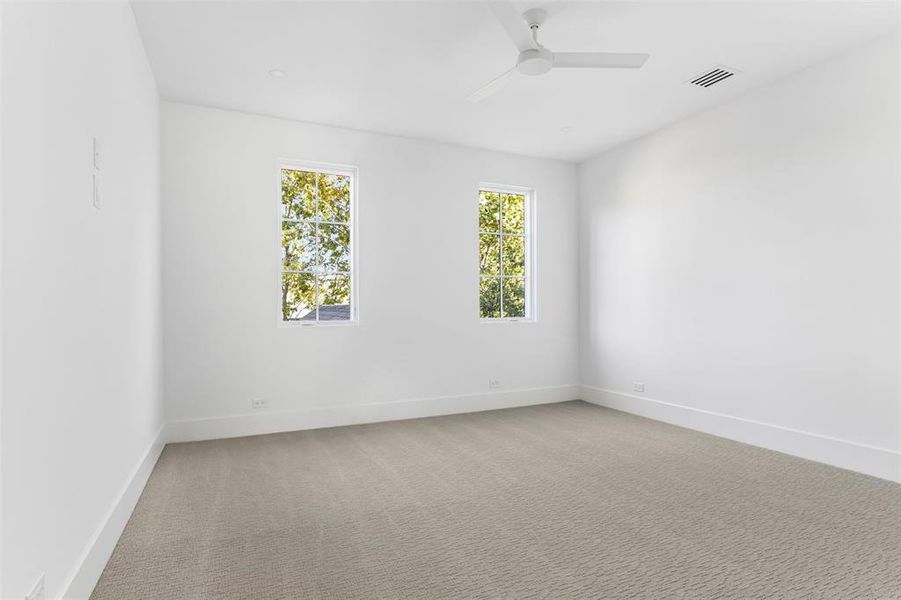 Spare room featuring light colored carpet and a ceiling fan Spare room featuring light colored carpet and a ceiling fan