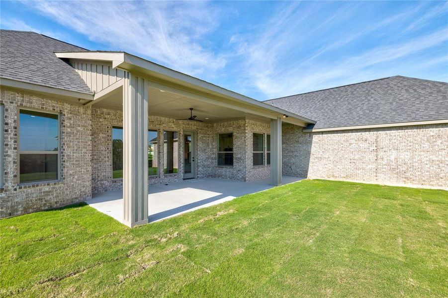 Rear view of property with a patio area, ceiling fan, and a yard