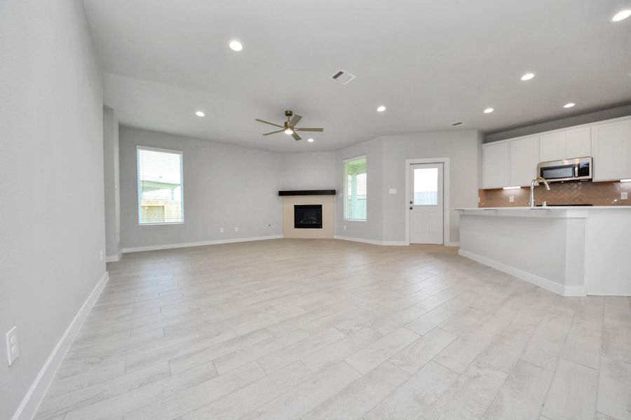 Relax and unwind in this inviting family room, illuminated by abundant natural light streaming in through tall windows, complemented by high ceilings and stunning flooring. Stay comfortable year-round with the gentle breeze from the ceiling fan, creating the perfect atmosphere for family gatherings. Sample photo of completed home with similar floor plan. Actual colors and selections may vary. Relax and unwind in this inviting family room, illuminated by abundant natural light streaming in through tall windows, complemented by high ceilings and stunning flooring. Stay comfortable year-round with the gentle breeze from the ceiling fan, creating the perfect atmosphere for family gatherings. Sample photo of completed home with similar floor plan. Actual colors and selections may vary.
