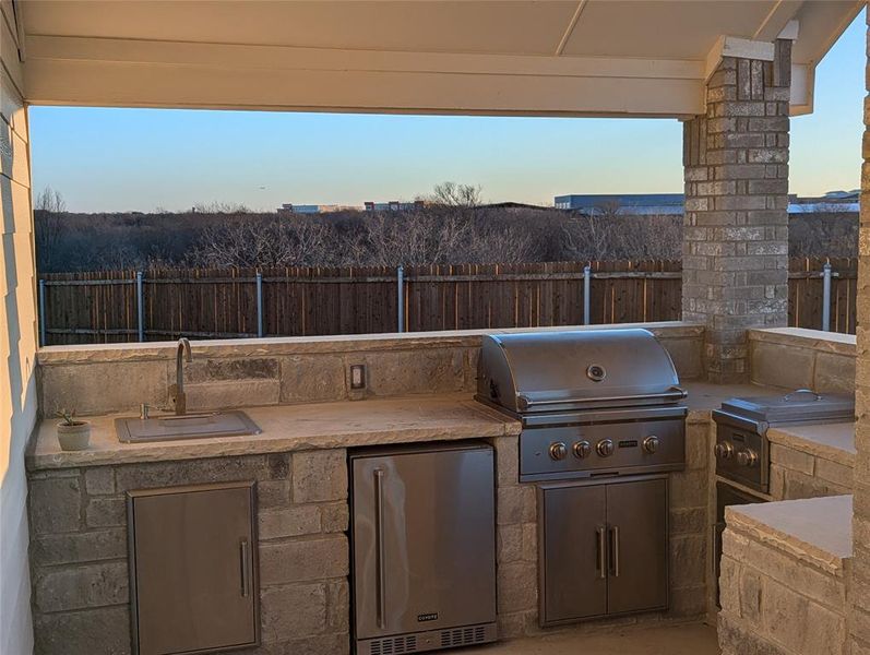 View of patio featuring an outdoor kitchen, area for grilling, and sink