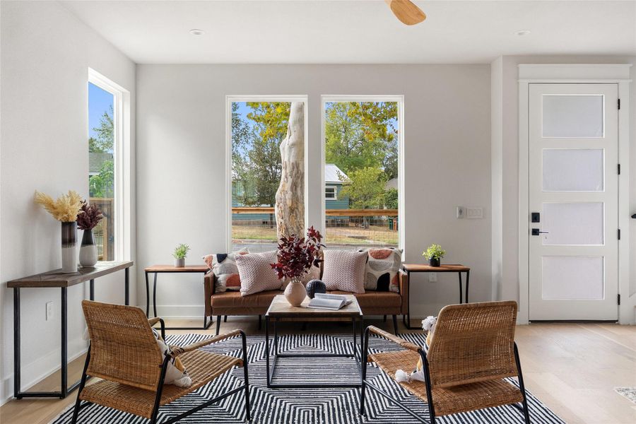 Sitting room featuring light wood-style flooring and ceiling fan Sitting room featuring light wood-style flooring and ceiling fan