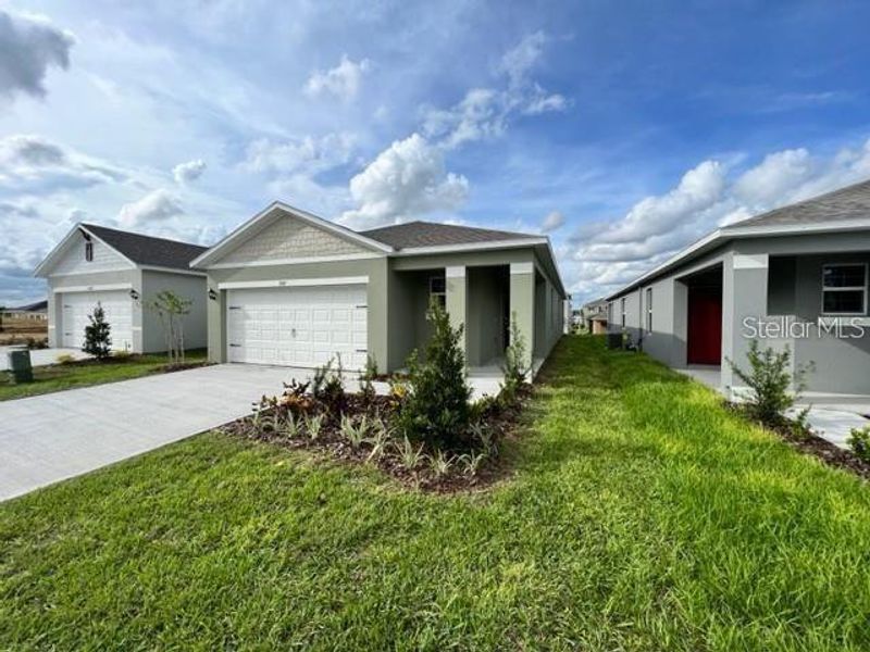 Front exterior of a new home in Astonia, Davenport, FL, highlighting curb appeal (Image 1).