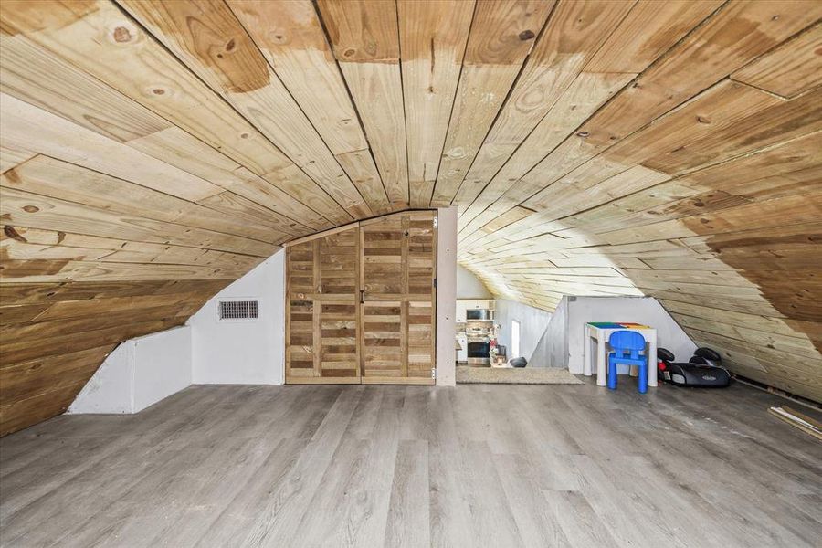 Additional living space with wooden ceiling and wood finished floors