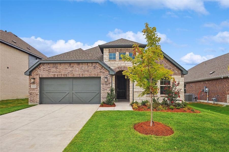 View of front of house with a garage, central AC, and a front yard