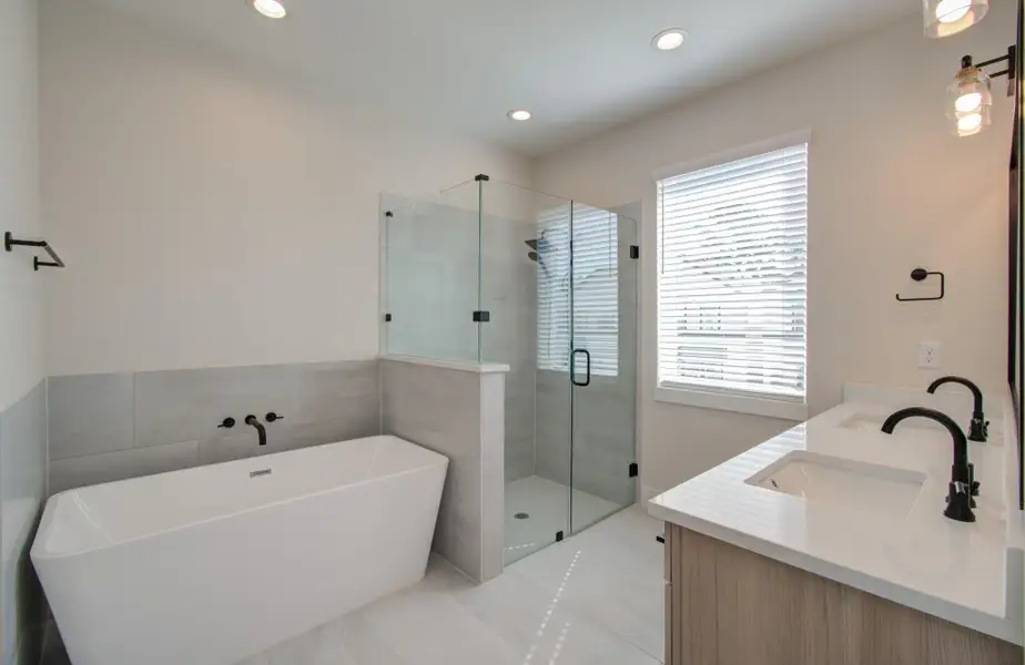 Indulge in a long soak in your deep, freestanding tub or refresh in the walk-in shower—both surrounded by modern elegance. An enclosed water closet ensures privacy while maintaining an airy, open design.
