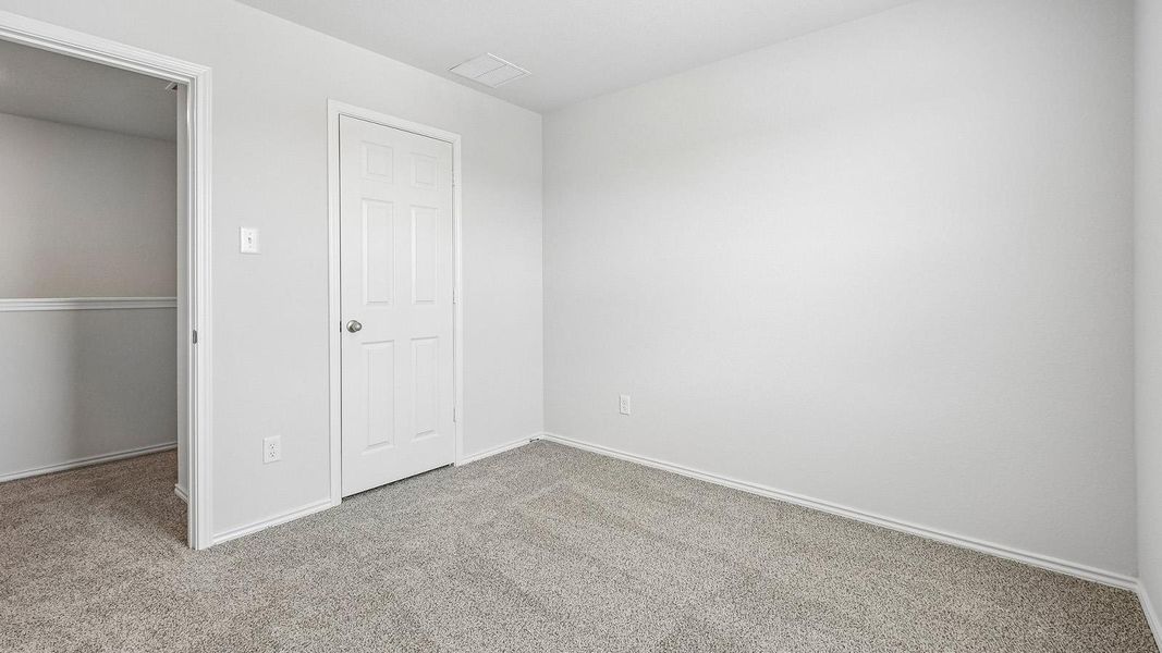 A spacious room offers neutral gray carpeting and fresh white walls, ready for your personal touch.