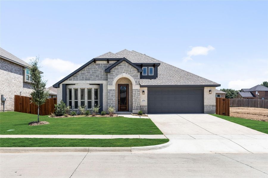 Single-story home with stone and brick exterior, arched entry, two-car garage, and green front lawn Single-story home with stone and brick exterior, arched entry, two-car garage, and green front lawn