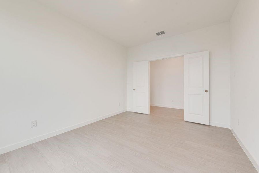 Spare room featuring light wood-style floors and baseboards