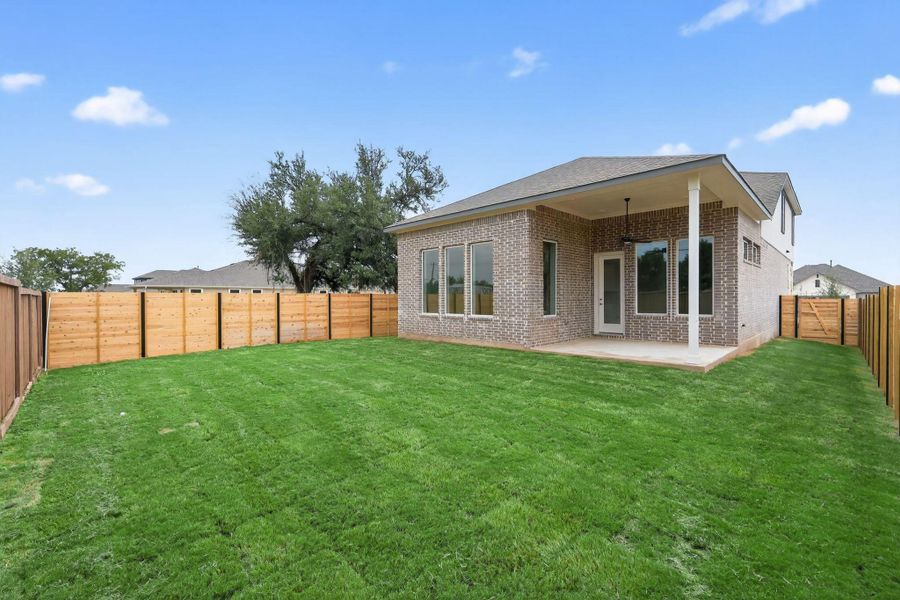 Back of property with a fenced backyard, a patio area, brick siding, and a shingled roof