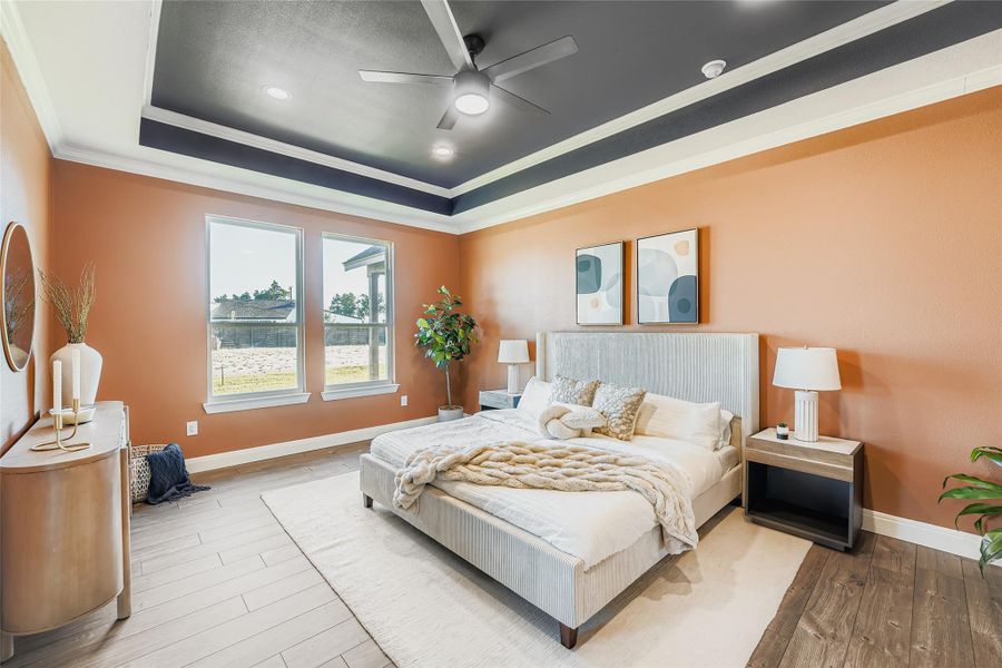 Bedroom with a raised ceiling, crown molding, hardwood / wood-style floors, and ceiling fan