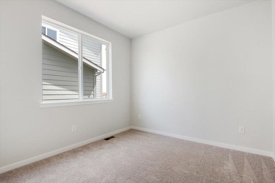 A room with a window and carpet.